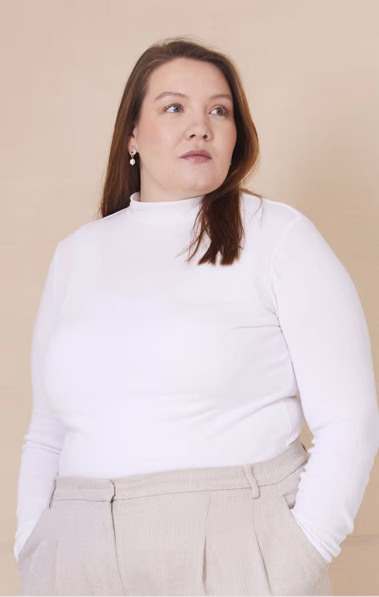 A white woman standing and looking to the side