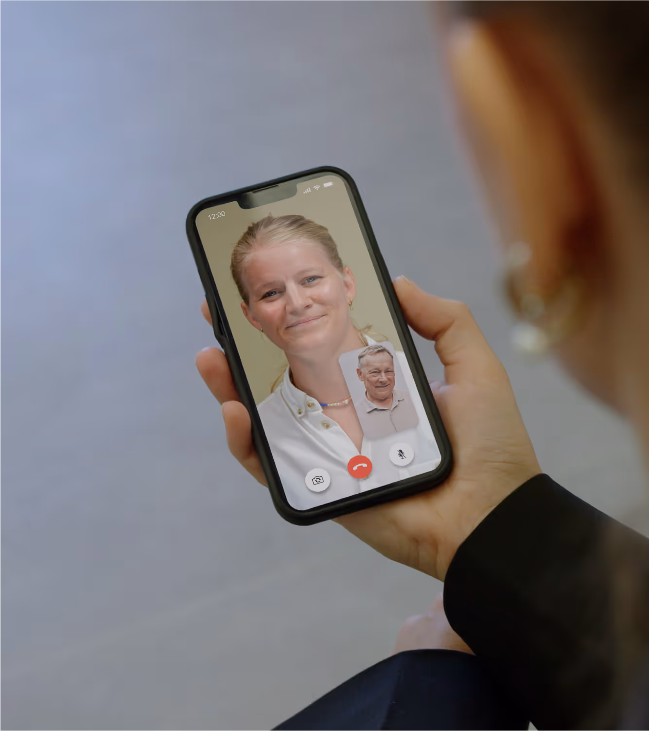 Medlem der snakker med sin sundhedscoach på Embla appen på en telefon.